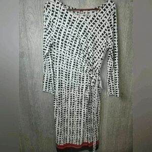 Ann Klein black and white design dress with orange strip stripe on bottom.